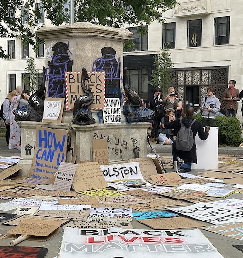 "a black lives matter protest by a statue"